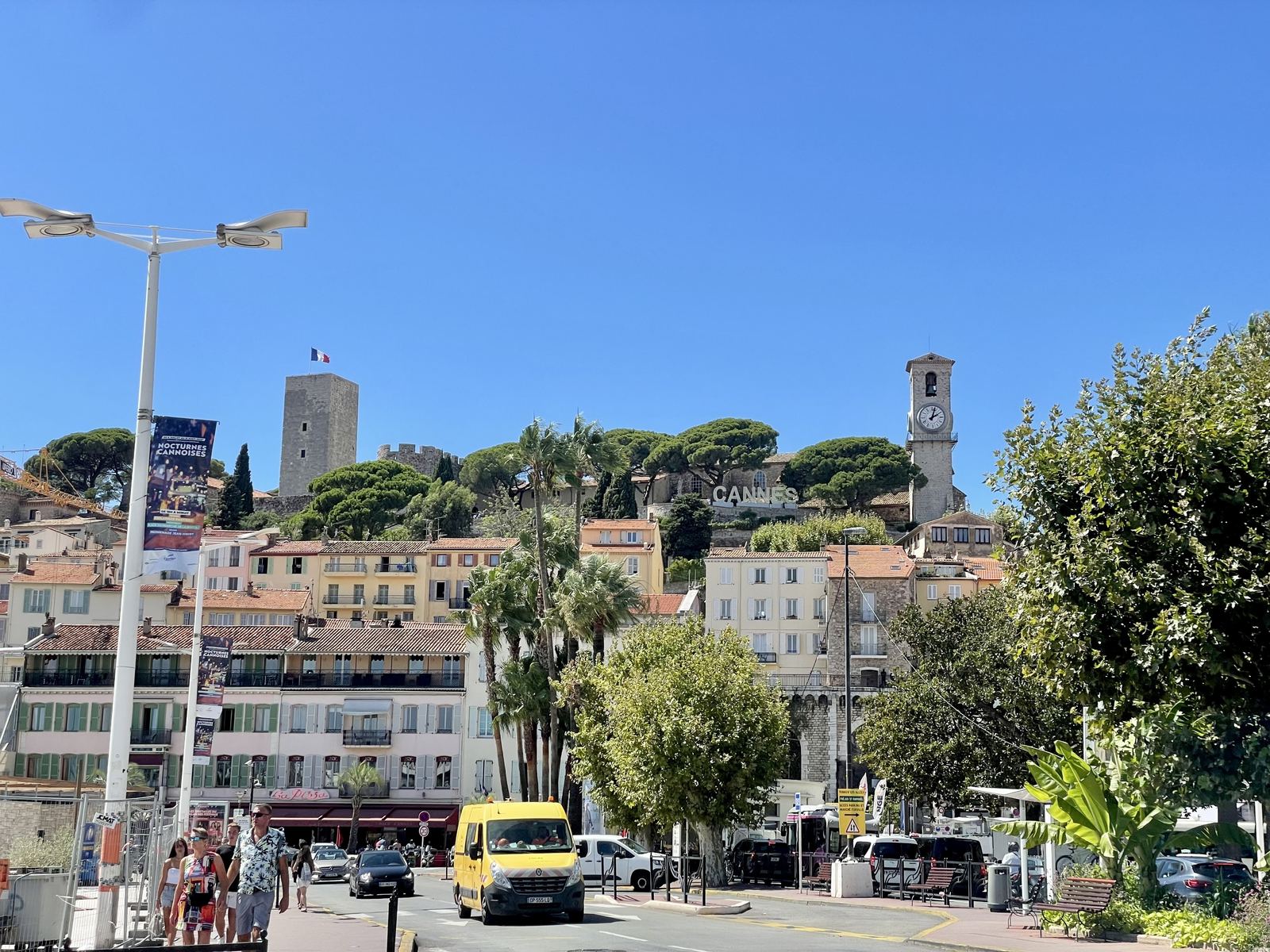 Cannes old town hillside — Le Suquet, the watchtower, clock tower, CANNES sign among the pines, vivid blue sky